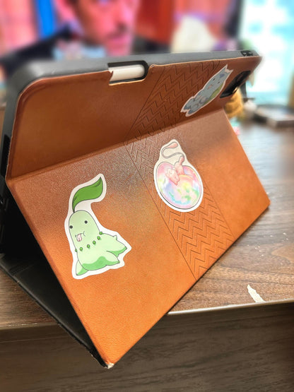 showing the stickers on an ipad case or the derpy pokemon stickers of bulbasaur, Chikorita, treecko, turtwig, snivy, chespin, grooky, rowlett, sprigatito